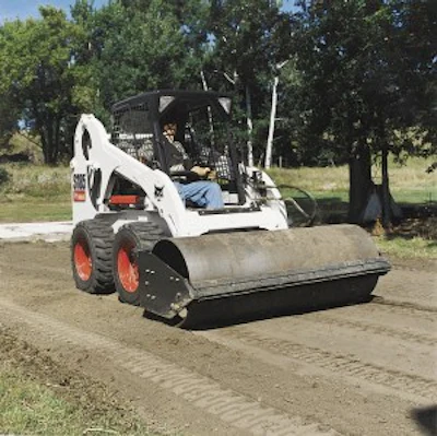 A vibratory roller attachment can be used for patch work and compaction of base material.
