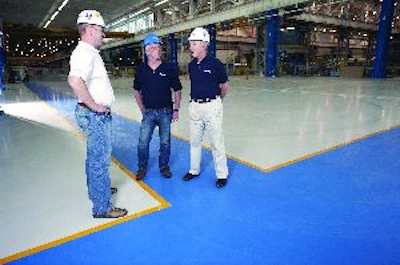 The management team at Healy, Long & Jevin stands on a recently completed industrial floor project where the company's place and finish crew installed superflat floors by hand, reaching FF and FL numbers well beyond specifications.