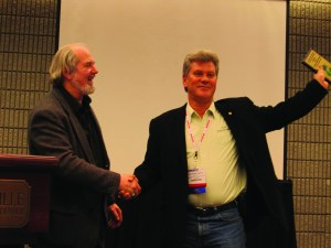 Ray Confer (right), president of C&J Parking Lot Sweeping, Warren, MI, accepts the 2011 WorldSweeper.com Award of Excellence in Power Sweeping from Ranger Kidwell-Ross, editor of WorldSweeper.com.