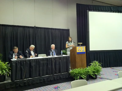 Dr. Heather Brown, right, speaks about the new concrete-focused MBA through CIM. Seated, from left to right: Mike Schneider, Senior VP at Baker Concrete and National Steering Committee member for CIM; Dean Jim Burton of the Jones College of Business at MTSU; and David Vickers, National Steering Committee member for CIM.