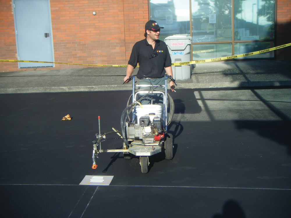 Nathan Witthuhn, owner of DMO Striping, is pictured completing striping work. DMO Striping offers services including crack fill, striping, sealcoating and infrared asphalt repair.