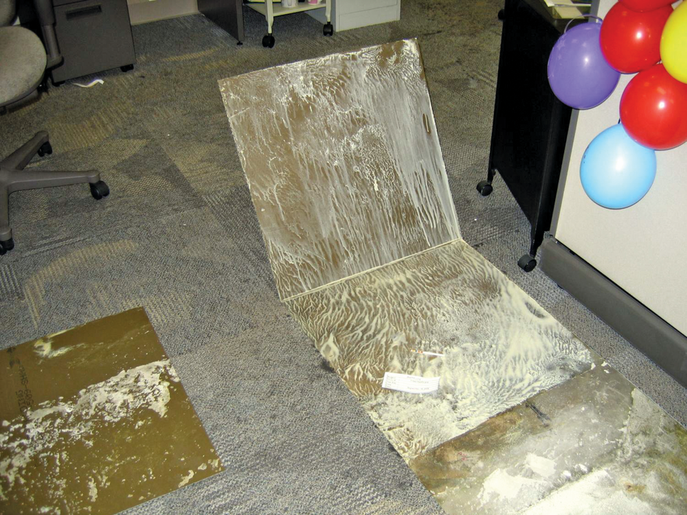 Water vapor that traveled through the concrete slab reached dew point and re-emulsified the water-based glue that once secured these carpet tiles to the concrete substrate.