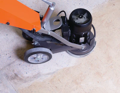 Grinding glue off a concrete floor.