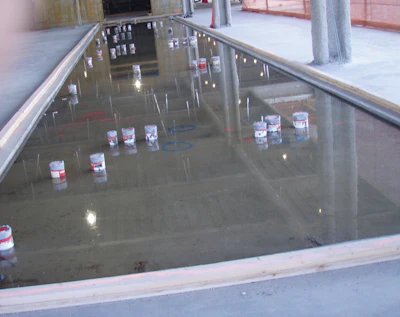 The penetrations required in this depressed area in an elevated floor slab make it difficult to use 10-foot straightedges and riding power trowels. Specifiers should consider these multiple obstructions to finishing operations when determining F-number values. In this case, the specifier required F-numbers in the small depressed floated area that was to receive ceramic tile for bathrooms.