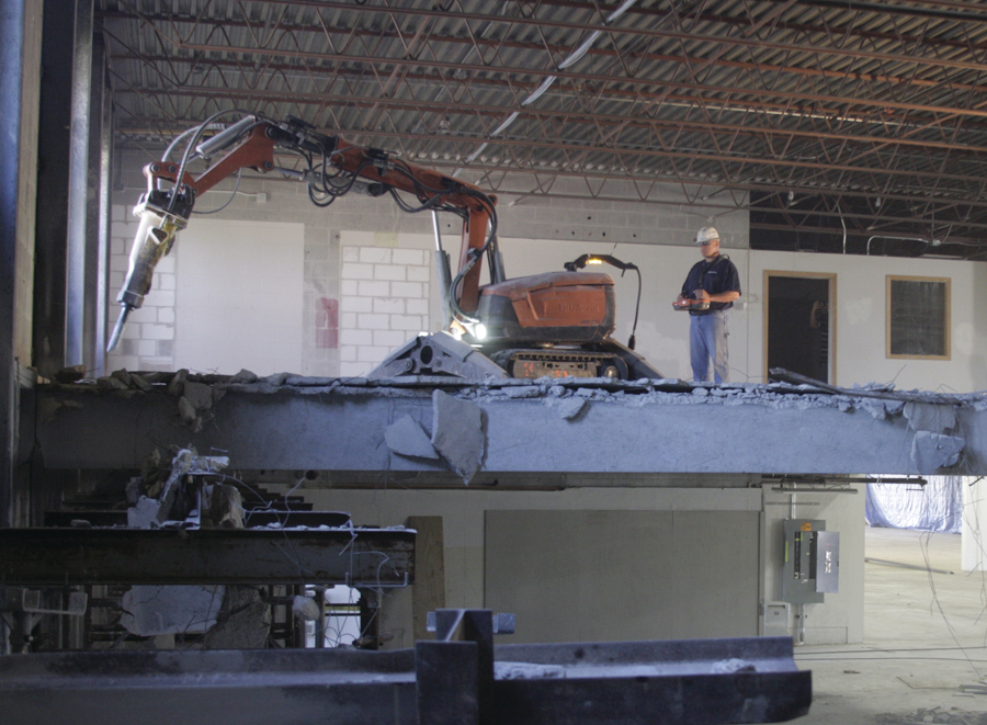 Husqvarna is moving in the direction of selling robots to demolish concrete, separating workers from exposure to vibration issues. Workers stand away from the machine and use joysticks to control the robot's movement.
