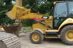 Dumping buckets of stone into an excavator bucket of a Cat 345.