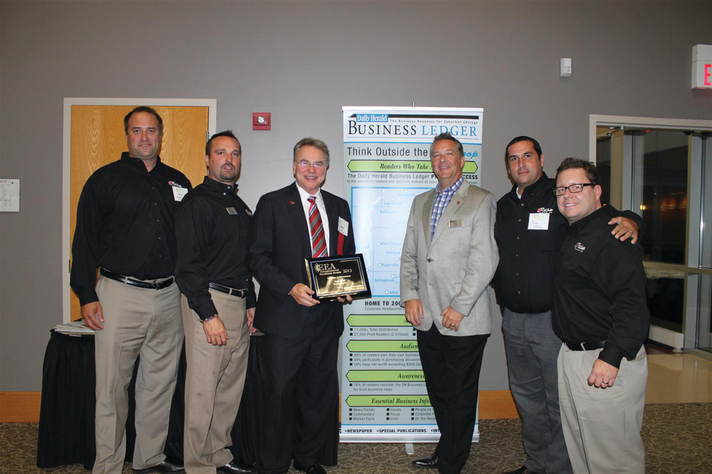 Alan Rose (holding plaque) accepts his Lifetime Achievement Entrepreneurial Excellence Award at a Sept. 11 ceremony. With Rose are some of his Rose Paving support (from left) Todd Dembinski, Larry Briar, Rose, Tim Chimack, Julio Chinea and Paul Price.