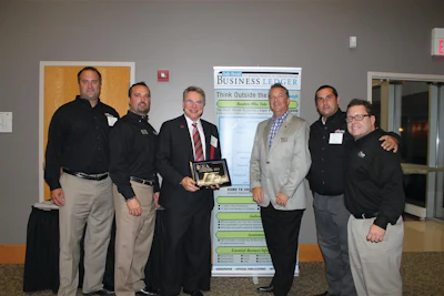 Alan Rose (holding plaque) accepts his Lifetime Achievement Entrepreneurial Excellence Award at a Sept. 11 ceremony. With Rose are some of his Rose Paving support (from left) Todd Dembinski, Larry Briar, Rose, Tim Chimack, Julio Chinea and Paul Price.