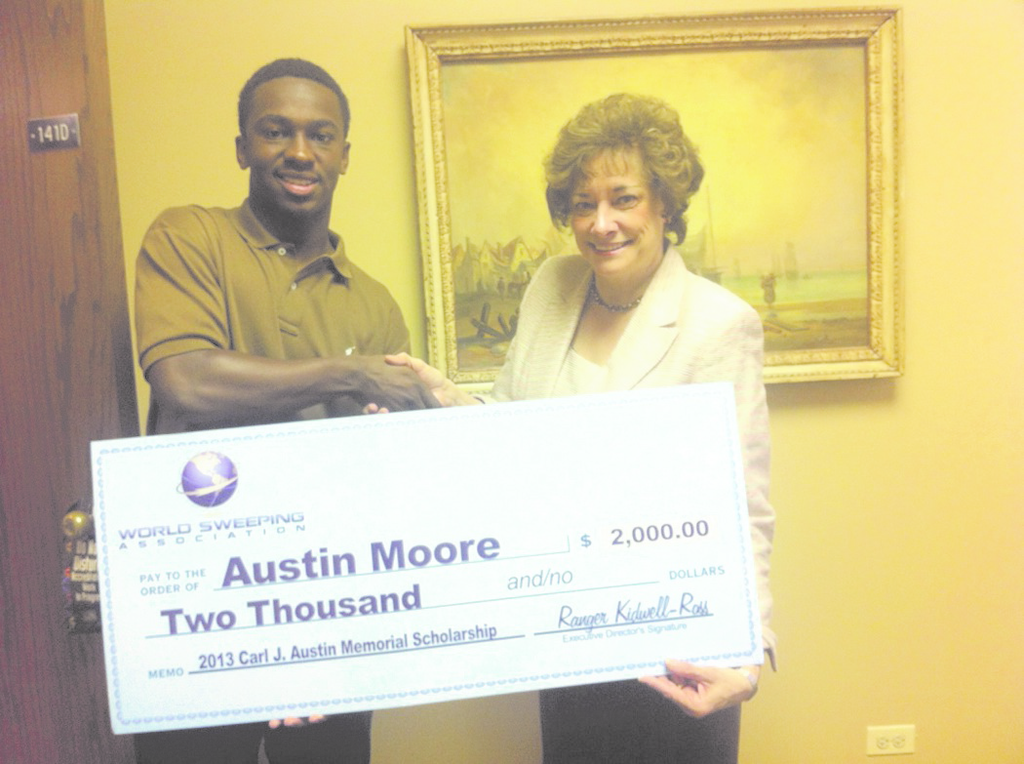As the recipient of the WSA 2013 Carl J. Austin Memorial Scholarship, Austin Moore accepts a $2000 check from Marilyn E. Reineck, Ph.D., Sr. Vice President for Academics, Concordia University Chicago. Austin's father, Rod Moore, is the general manager for C&J Parking Lot Sweeping, a WSA member, so the scholarship was doubled to $2,000.