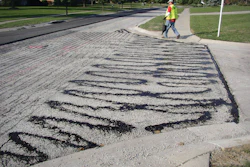 Improper application of tack coats, like this tack that was applied by hand using a pour bucket, eliminates any benefits that can result from using tack coats to improve paving.