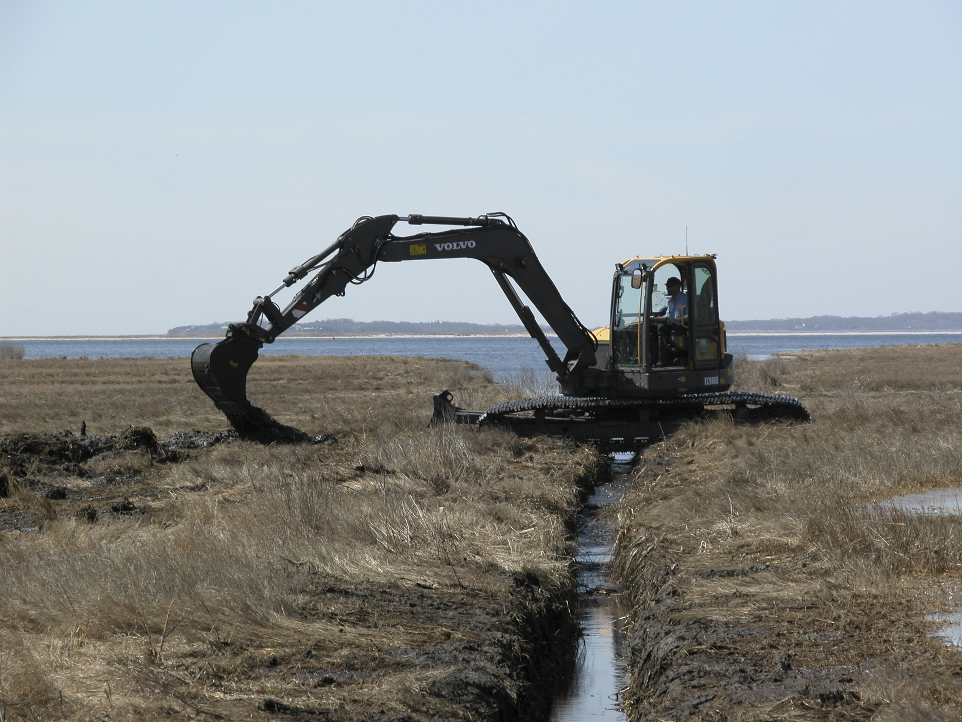 A Volvo ECR88 D-Series excavator fitted with unique swamp pads is working in the Connecticut coastal wetlands for the Wetlands Habitat and Mosquito Management (WHAMM) Program.