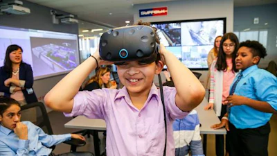 A seventh grader from DREAM tries on VR goggles in the Smart Lab during a visit to the Suffolk offices.