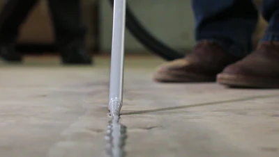 Today's joint fillers are intentionally over-applied in warehouse and industrial applications, and flush-trimmed with a floor razor to keep out debris and protect slab edges from spalling.
