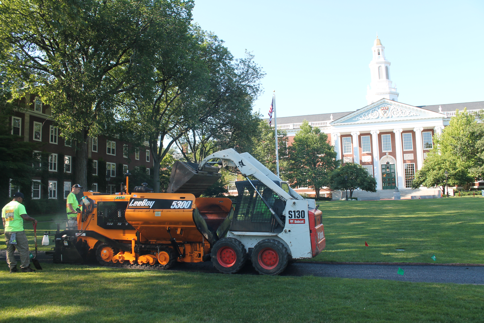 Access to the high-profile site was restricted so crews delivered the porous hot mix asphalt from trucks to the cart-path paver using small Bobcat skid steers.
