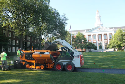 Access to the high-profile site was restricted so crews delivered the porous hot mix asphalt from trucks to the cart-path paver using small Bobcat skid steers.