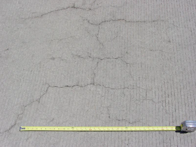Occurring in both random and parallel patterns, plastic shrinkage cracks are discontinuous, relatively short and typically fairly shallow. Occasionally they can become full-depth cracks. Parallel cracks are typically spaced between a few inches to several feet apart and many times are oriented perpendicular to the prevailing wind direction. Cracks widths at the surface can be fairly wide (as much as 1/8 in.) but rapidly diminish with depth.