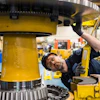 Komatsu employee at the Peoria, Ill., plant inspects an electric dump truck component. Komatsu has 28 U.S. manufacturing facilities that produce construction, mining, forklift and forestry equipment.