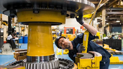 Komatsu employee at the Peoria, Ill., plant inspects an electric dump truck component. Komatsu has 28 U.S. manufacturing facilities that produce construction, mining, forklift and forestry equipment.