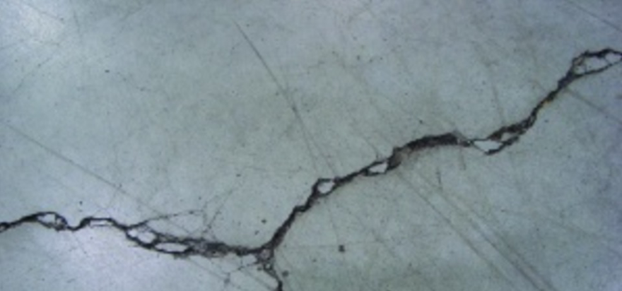 Unrestricted crack width growth leads to spalled edges along out-of-joint cracks when exposed to wheeled traffic.