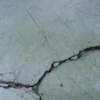 Unrestricted crack width growth leads to spalled edges along out-of-joint cracks when exposed to wheeled traffic.