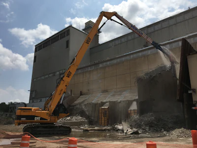 Veit utilized the Brokk 500 to take two of the structures down to 120 feet, bringing them within reach of a CAT 365 Ultra-High-Reach excavator that demolished the remaining portions of the smokestacks.