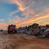 Red Dump Truck Near Filed Rocks Under Cloudy Sky 1044290