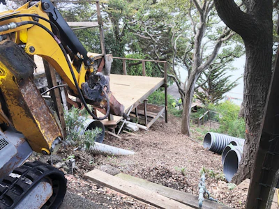 Working in tandem with a 25-ton tow truck parked on the road, Jamba maneuvered the Brokk machine down the hillside.