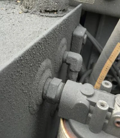Hydraulic tank that has been covered with dirt and oil from a leak. The cap on the hydraulic tank is vented, and if the debris gets into the tank the oil will be contaminated.