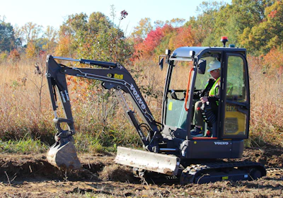 The ECR25 Electric compact excavator is digging trenches to improve drainage from the pond and helping to build a viewing platform over the pond.