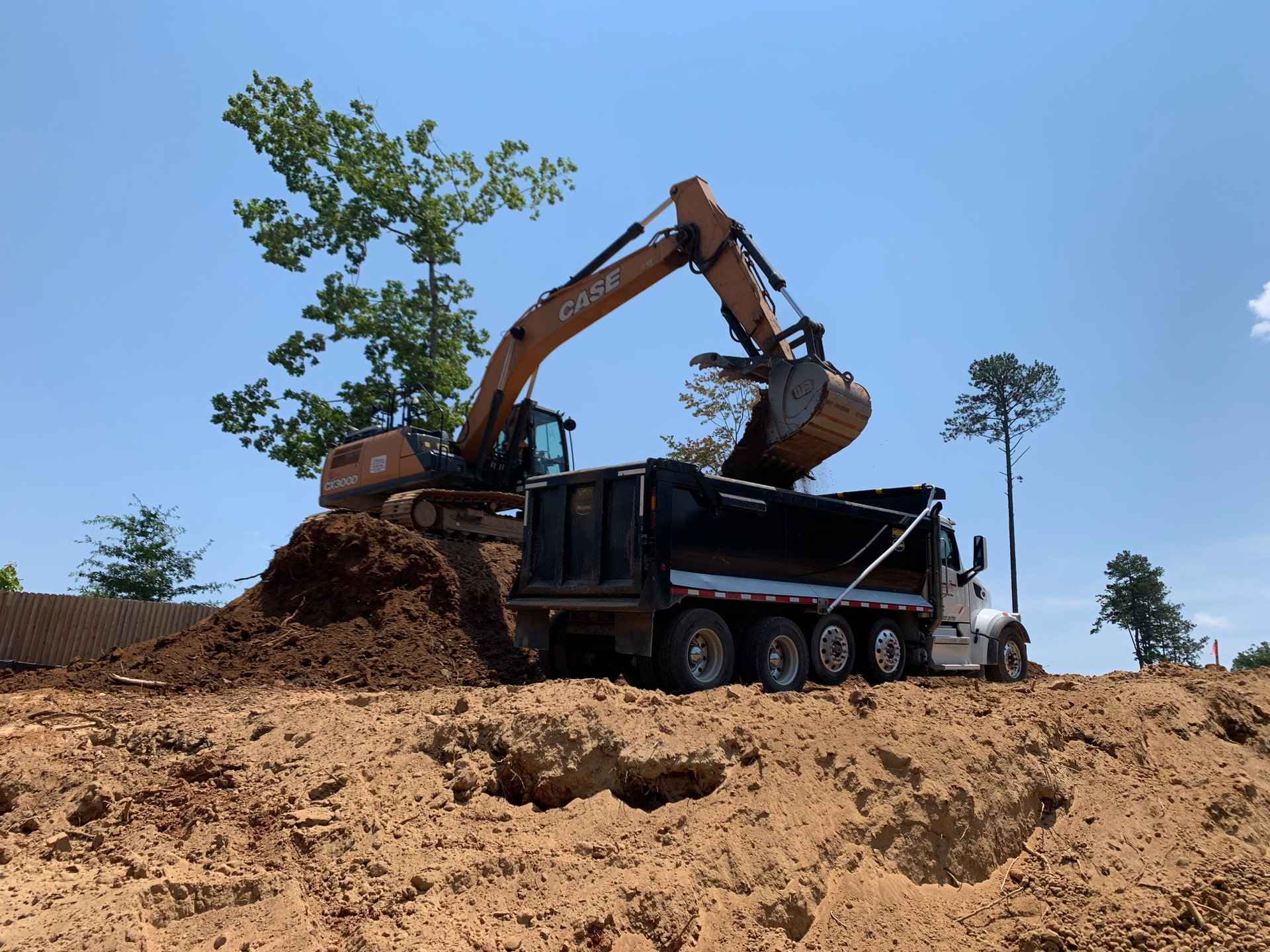 Case 300 excavators fitted with Werk-Brau 54-in. heavy-duty buckets cleared any remaining trees, grubbing them out along with the stumps and root balls left from the logging process.