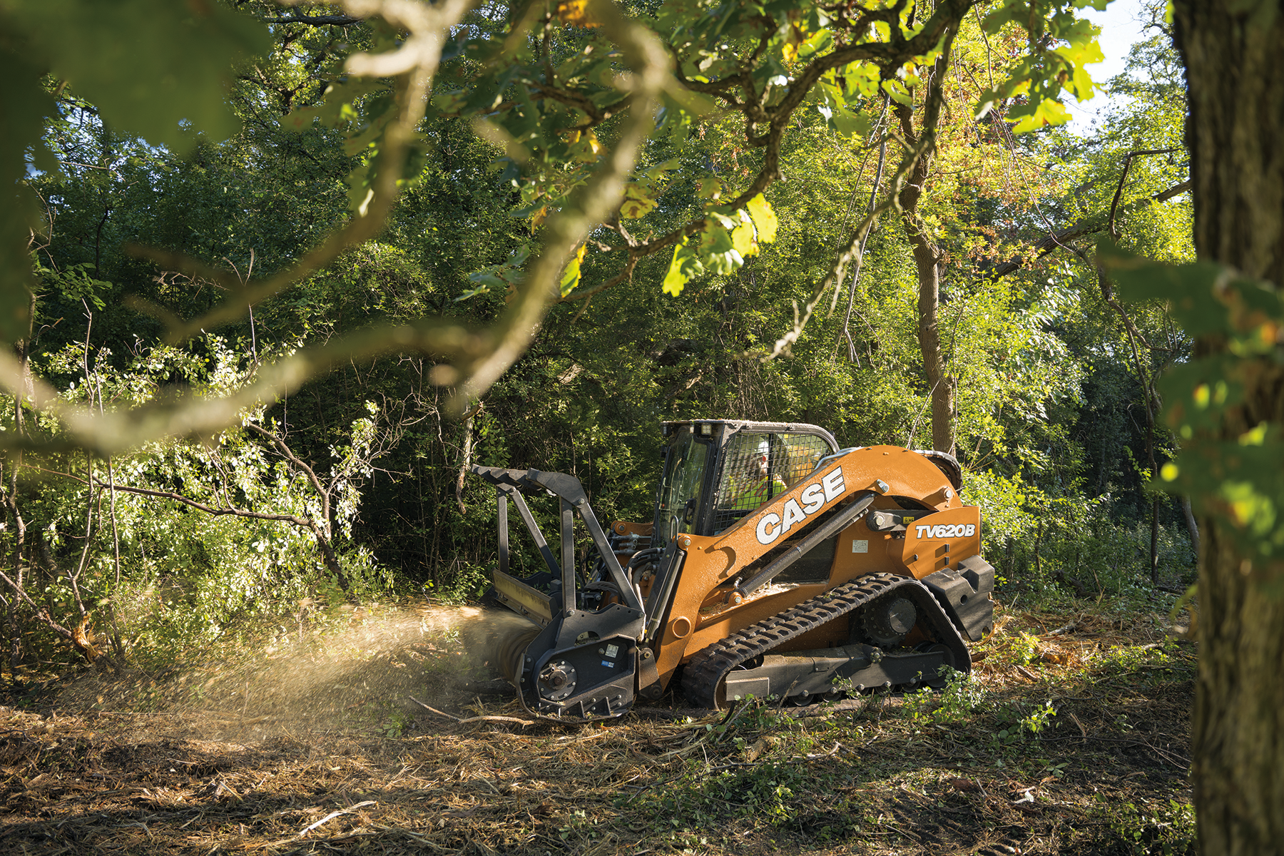The CASE TV620B tackles a mulching task on soft ground in a heavily wooded area.