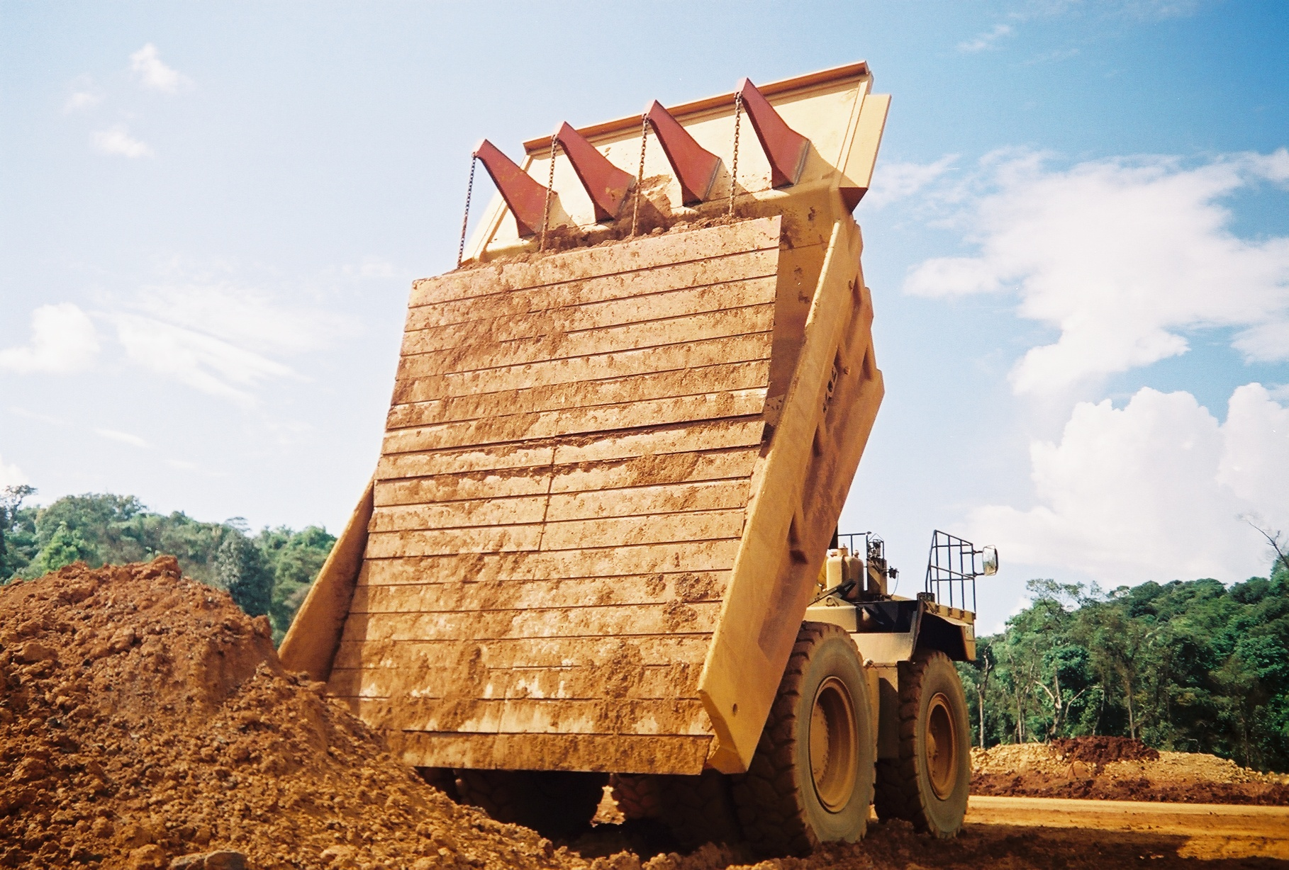 Carryback works against efficiency by reducing payload in the haul truck as residual material is left sticking to the sides and bottom of the truck, decreasing hauling capacity for subsequent loads.
