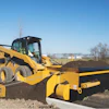 The accessory extends to the left or right of the FH-R and dispenses material over the curb to backfill with dirt or aggregate.