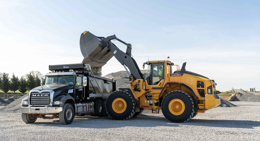 The machine is designed for rehandling applications, with a high tipping load and long reach to fill a truck in three passes.