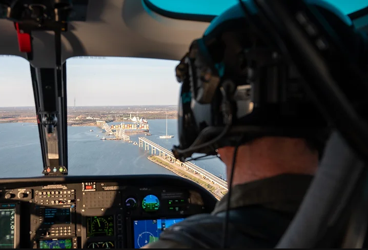 A Maryland Natural Resources Police officer conducts an overflight assessment of the M/V Dali, a 948-foot Singapore-flagged container ship, and Francis Scott Key Bridge in the Patapsco River in Baltimore, Md.