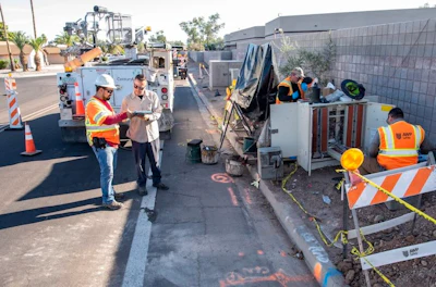 Road construction crew working on utility infrastructure with safety equipment