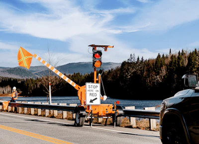 Highway traffic control station with red light and safety barrier on mountain road