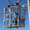 Utility worker in elevated bucket lift servicing power transmission lines