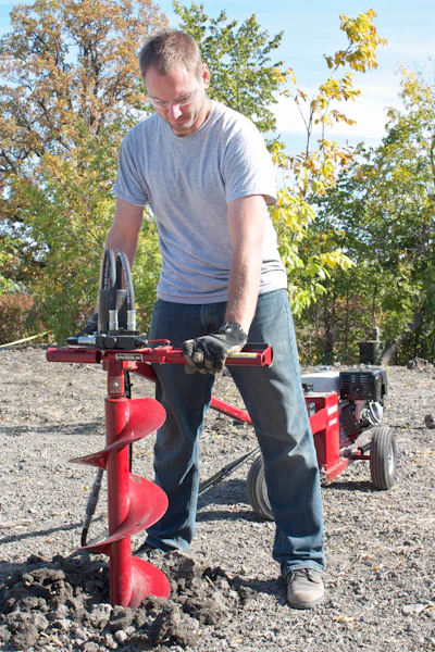 A machine with a chassis-mounted drill carriage and a torque tube transfers kickback to the chassis instead of the operator for increased safety.
