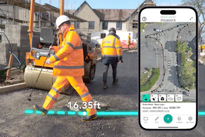 Construction workers using digital measurement technology while paving road with roller
