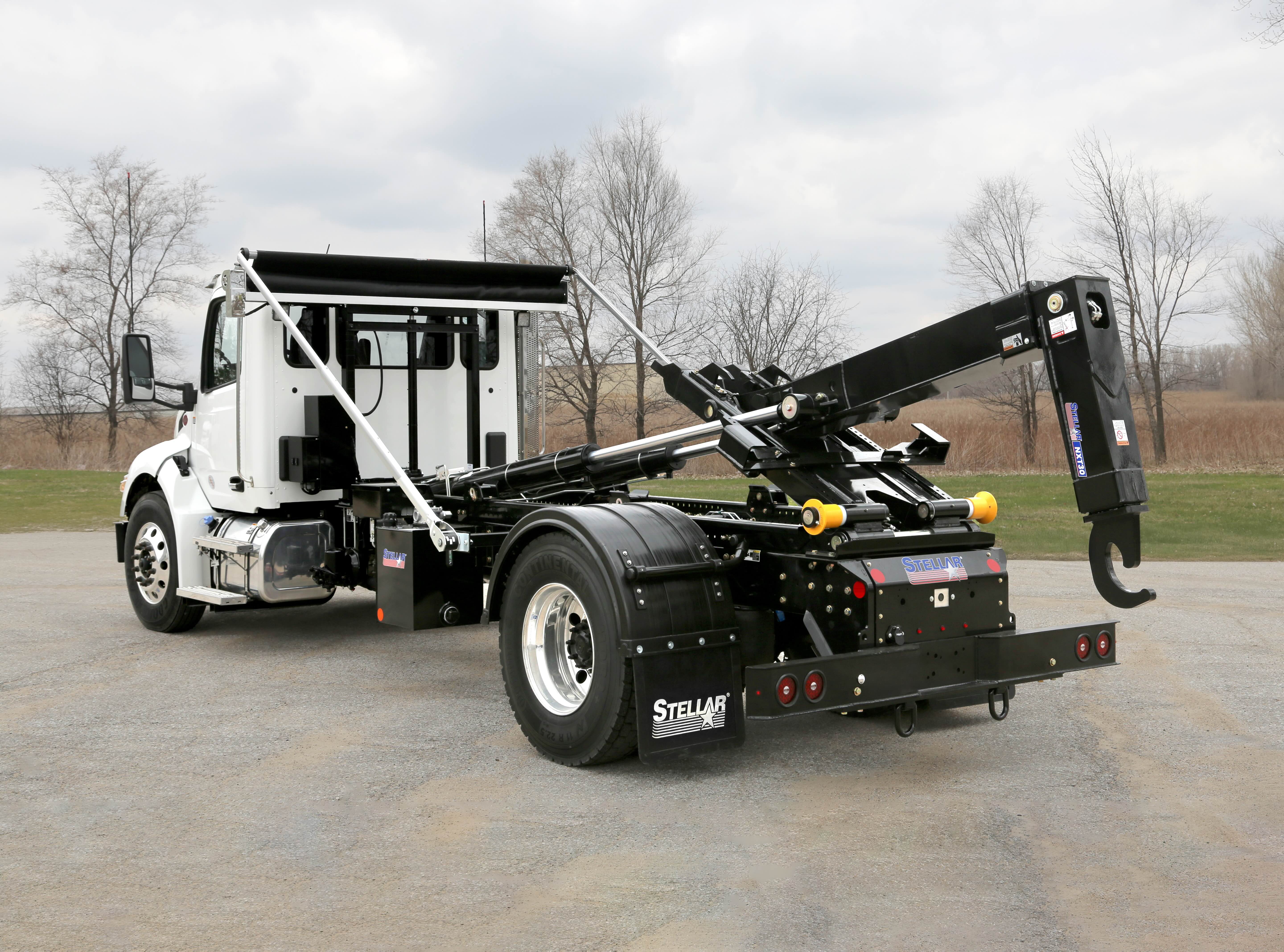 Stellar hook lift truck with hydraulic arm on industrial work site