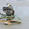 Construction power trowel on concrete with gasoline engine and circular metal frame