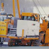 Heavy yellow tracked industrial vehicle in snowy construction site