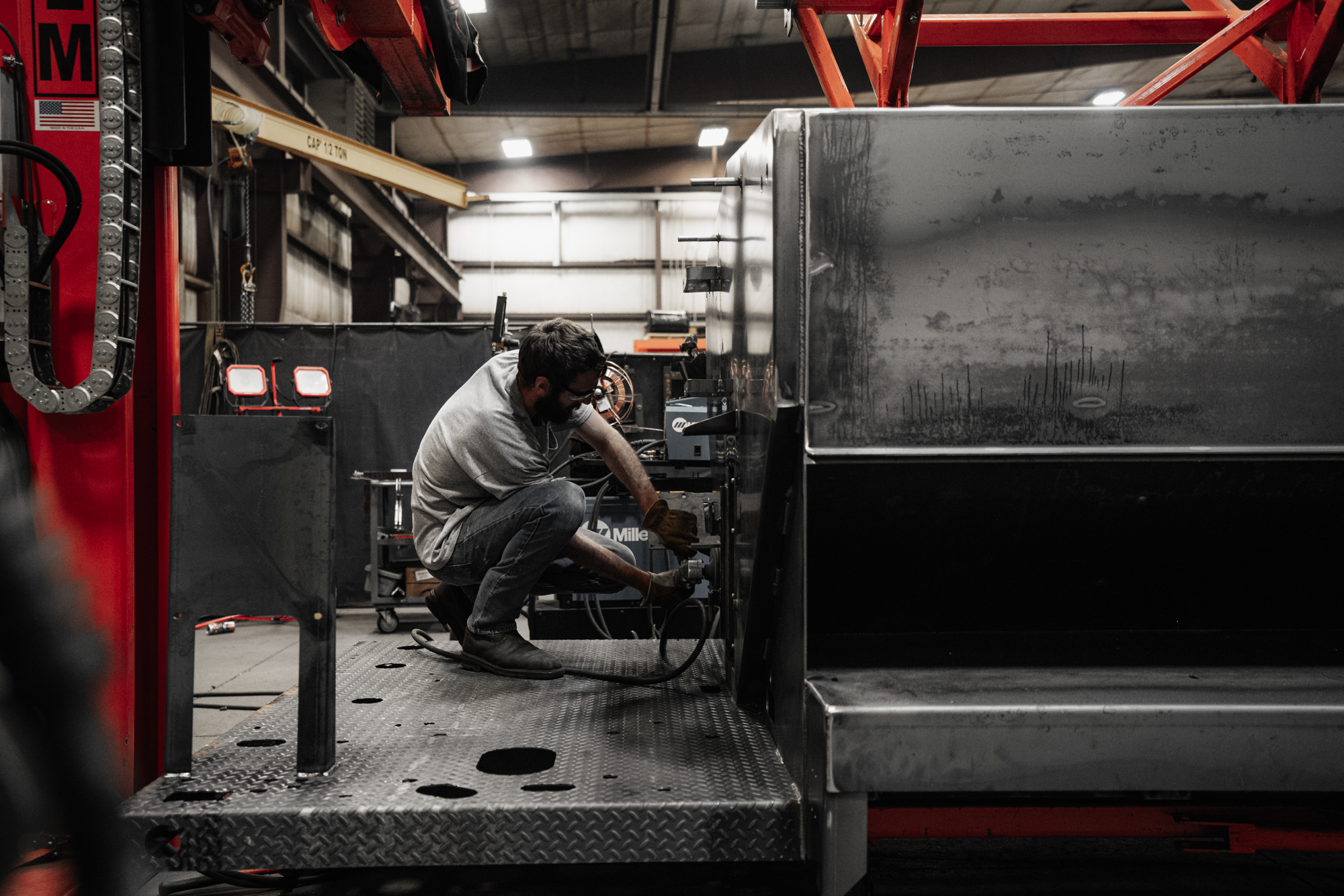 Technician working on machinery in dimly lit industrial workshop