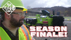 Construction worker in safety vest and hard hat near green industrial machinery