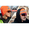 Two workers wearing bright orange Ergodyne winter hats and protective sunglasses