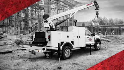 White utility service truck with crane at construction site with scaffolding