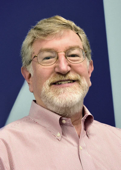 Smiling senior man with gray hair and beard wearing glasses and red striped shirt