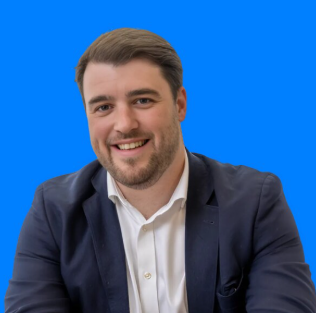 Smiling professional in navy blazer against bright blue background