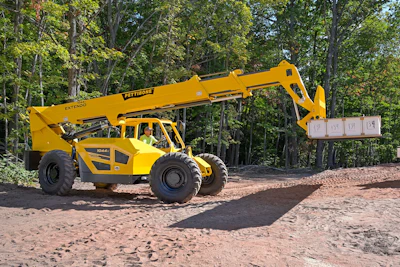 Yellow Pettibone telehandler on dirt path surrounded by trees